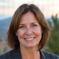 Smiling portrait of Coach Elara Vance, a woman in her late 40s