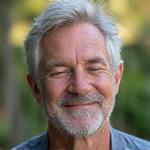 Man in his early 50s, Mark T., practicing yoga outdoors with a serene expression.